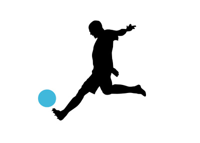 Silhouette of a football player about to kick the ball