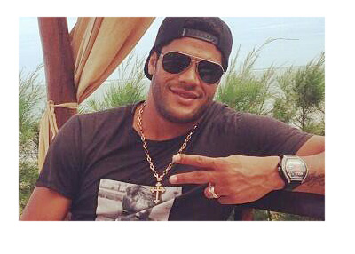 Hulk is relaxing with palm trees in the background. Large gold chain around his neck and sunnies