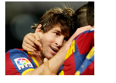 Long haired Lionel Messi celebrating a goal with Barcelona FC players