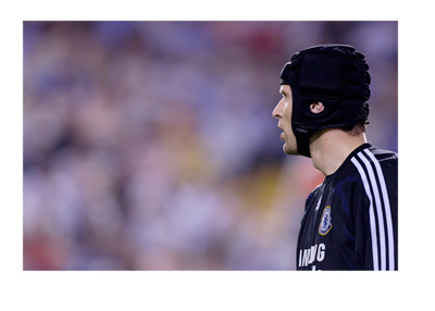 Petr Cech, wearing a Chelsea FC jersey, is looking into the distance.  Linked with a move to Arsenal