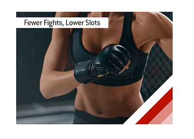 Female MMA fighter holding her black-gloved hands together inside an Octagon.