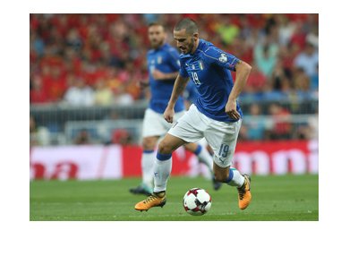 Italian defender, Leonardo Bonucci, dribbling the ball wearing the home blue national side kit. Year is 2017.
