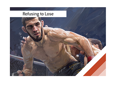 Islam Makhachev grappling with an opponent against the Octagon fence.