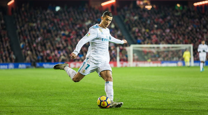 Real Madrid forward, Cristiano Ronaldo, is photographed shooting the ball.  The year is 2017.  He is wearing the home white jersey.