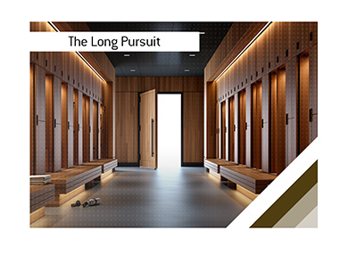 Empty modern professional sports locker room with luxurious wood lockers, benches, and an open doorway glowing with bright light.