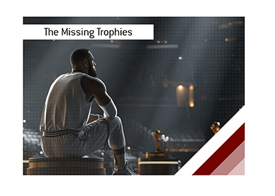 LeBron James is seated beside MVP trophies in a dark arena reflecting on overlooked MVP seasons and missing awards.