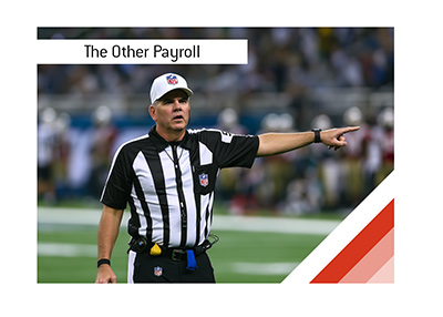 NFL referee making a first-down signal. How much do referees get paid in professional sports?