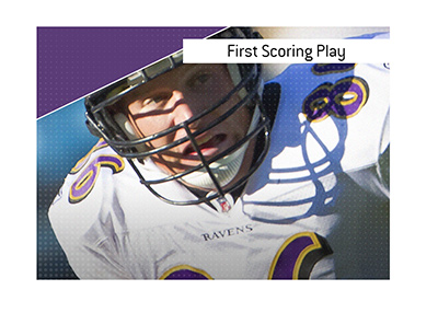 In photo: Baltimore Ravens football player holding the ball.  The meaning of the term First Scoring Play is explained when it comes to betting on the sport.