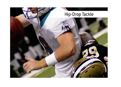 The Hip-Drop Tackle explained.  What is it.  In photo: Defensive football player is bringing down an offensive football player by the hip.