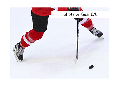 In photo:  A hockey player is taking a shot on goal.  The meaning of the sports betting term Shots on Goal O/U is explained.